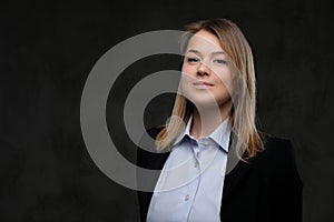 Portrait of a smiling blonde businesswoman formal dressed. Isolated on dark textured background.