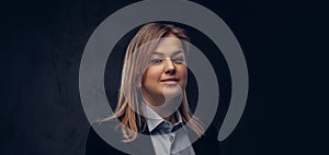 Portrait of a smiling blonde businesswoman formal dressed. Isolated on dark textured background.