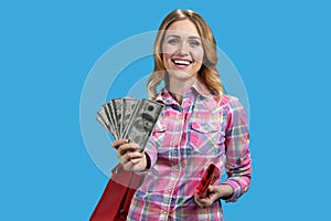 Portrait of smiling blonde woman giving fan of dollars money.