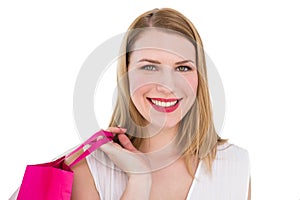 Portrait of a smiling blonde woman holding shopping bag