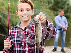 Portrait of smiling boy having fish in hands