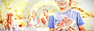 Smiling boy holding watermelon in the park