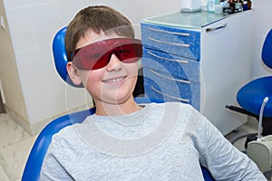 A portrait of a smiling boy in the safety glasses at the dentistÃ¢â¬â¢s photo