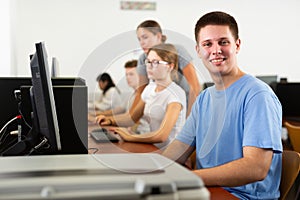 Portrait of smiling boy student looking at camera during lesson in computer class