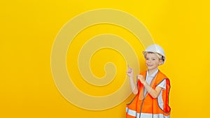 Portrait of a smiling boy in a white hard hat and orange signal vest