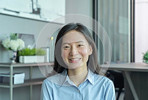 Portrait of smiling business Asian, Chinese woman person working from home and talking to her colleagues in webcam group video