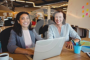 Portrait of smiling business executives sitting at desk