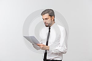 Portrait of a smiling business man with documents isolated on white background. Studio shot.