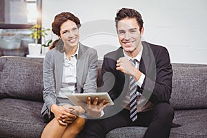 Portrait of smiling business people using digital tablet