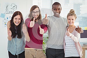 Portrait of smiling business team with thumbs up