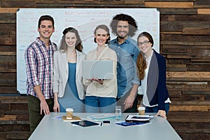 Portrait of smiling business team using laptop