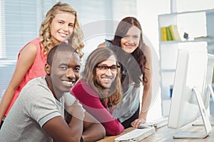 Portrait of smiling business team working at computer desk