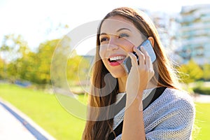 Portrait of smiling business woman having a conversation on her cell phone outdoors