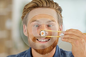 Portrait smiling businessman eating sushi with chopsticks