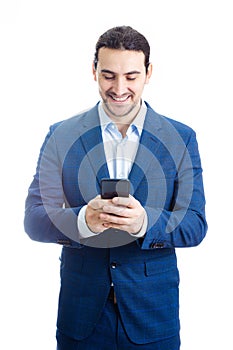 Portrait of a smiling businessman looking at his phone reading good news . Businessman receiving news with satisfied  positive