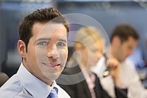 Portrait of smiling businessman in office, looking camera