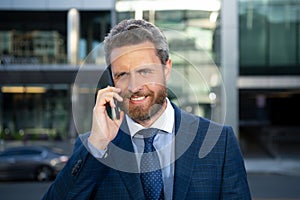 Portrait of smiling businessman outdoors. Closeup of happy mature business man outdoor. Urban man talking on smart phone