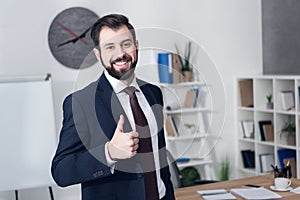 portrait of smiling businessman showing thumb up