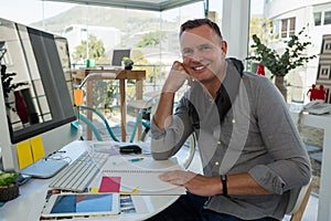 Portrait of smiling businessman sitting at desk