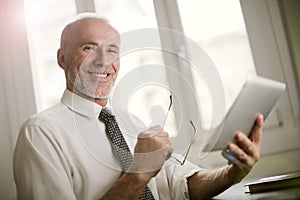 Portrait of a smiling businessman with a tablet