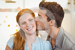 Portrait of smiling businesswoman being kissed