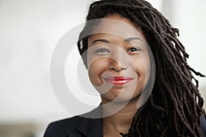 Portrait of smiling businesswoman with dreadlocks, head and shoulders