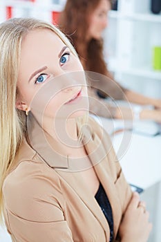 Portrait of smiling businesswoman, with female colleague on the background.