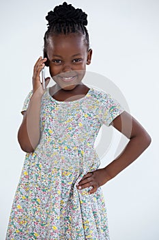 Portrait of smiling businesswoman with hand on hip talking on mobile phone