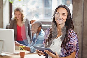 Portrait of smiling businesswoman holding digital tablet