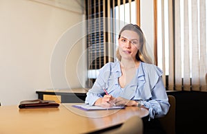 Portrait of smiling businesswoman in modern office at negotiating table