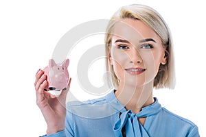 portrait of smiling businesswoman showing piggy bank