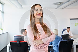 Portrait of smiling businesswoman standing at startup office