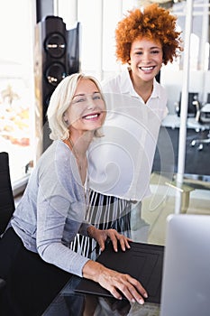 Portrait of smiling businesswomen at desk
