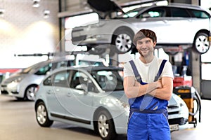 Portrait smiling car mechanic in a workshop - closeup with in th