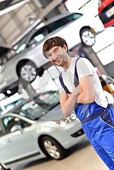 Portrait smiling car mechanic in a workshop - closeup with in th