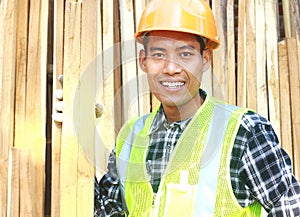 Portrait of a smiling carpenter holding wood