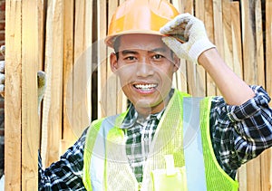 Portrait of a smiling carpenter holding wood