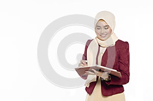 Portrait of smiling casual girl refering schedule in her planner