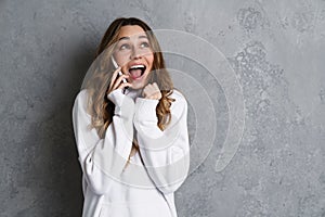 Portrait of a smiling casual woman holding smartphone