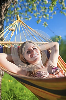 Portrait of Smiling Caucasian Blond Lady Resting in Hummock During Spring Time