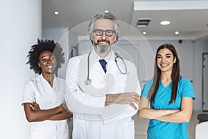 Portrait of smiling caucasian male doctor wear white medical uniform, stethoscope and glasses look at camera posing in private