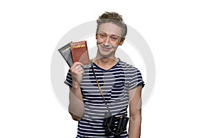 Portrait of smiling caucasian male tourist with passports and binoculars.