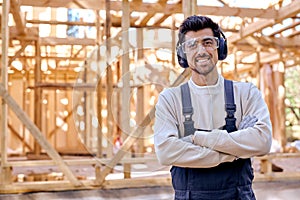 Portrait of smiling caucasian man in headset and uniform at work place, wooden house