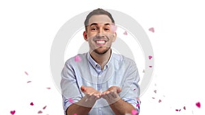 Portrait smiling charismatic man blowing pink heart small confetti love party posing isolated slowmo