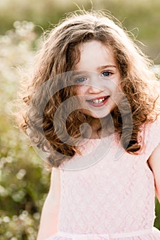 Portrait of a smiling charming little girl with curly hair