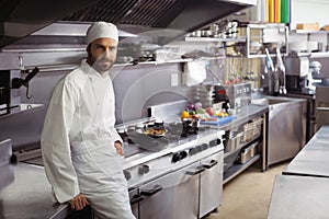 Portrait of smiling chef standing in commercial kitchen