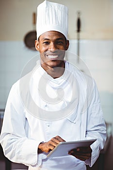 Portrait of smiling chef using digital tablet