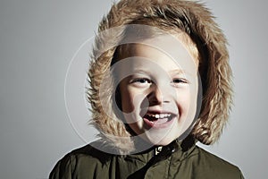 Portrait of Smiling child in fur hood and winter jacket. fashion kid.children.parka.little boy winter style