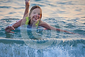 Portrait of a smiling child, a girl on an inflatable ring in the sea or pool.