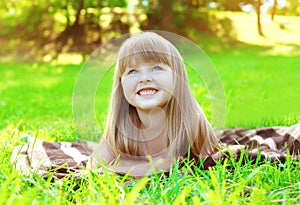 Portrait of smiling child lying resting on the grass in summer